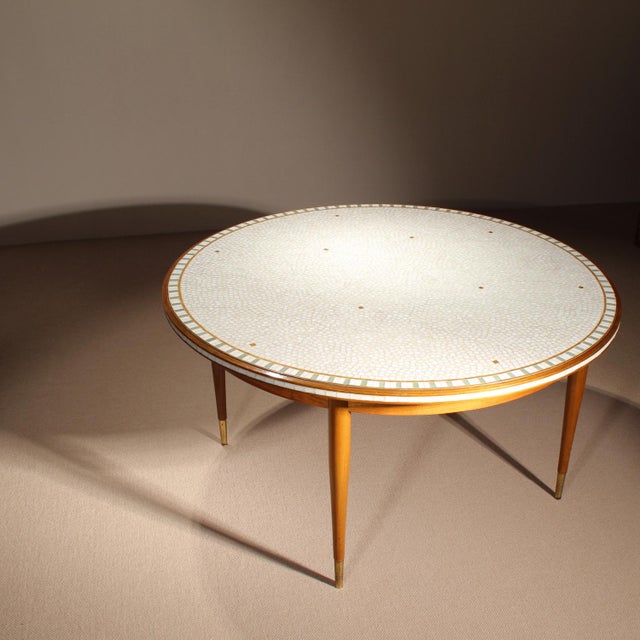 ​This round coffee table was produced in the workshops of Berthold Müller. The tabletop features a mosaic of light,...