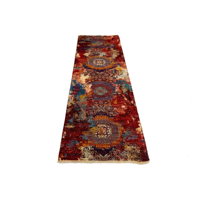 This contemporary hand-knotted rug features a striking tribal design with a vibrant, multicolored scheme. Crafted from...