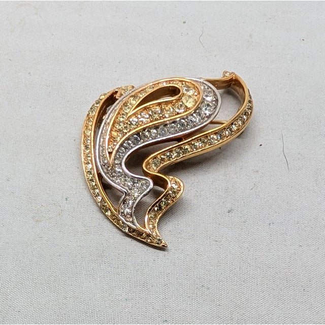 1960s abstract goldtone openwork round faux-citrine and clear rhinestones brooch with security clasp. Marked crown...