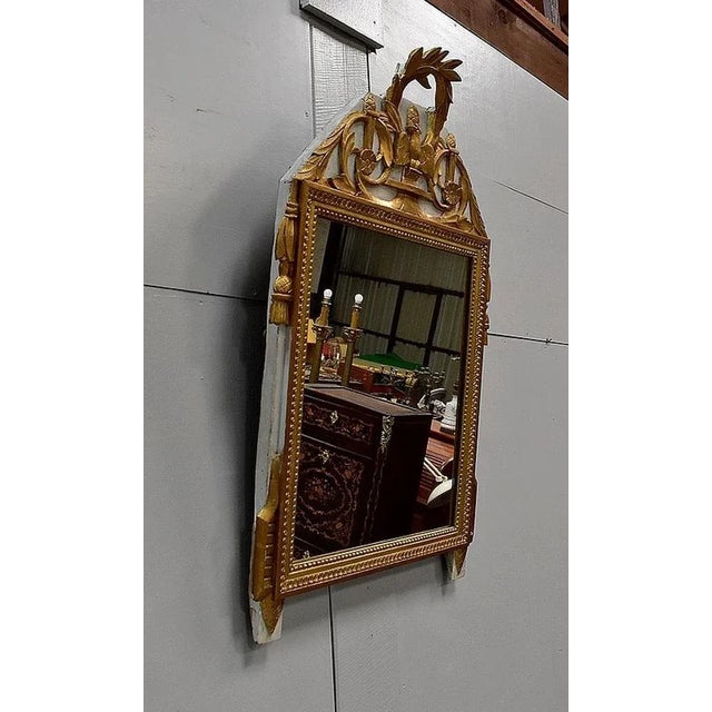 Small wall mirror in golden and lacquered wood, of Louis XVI style. Its ice, rectangular and in perfect condition, is...