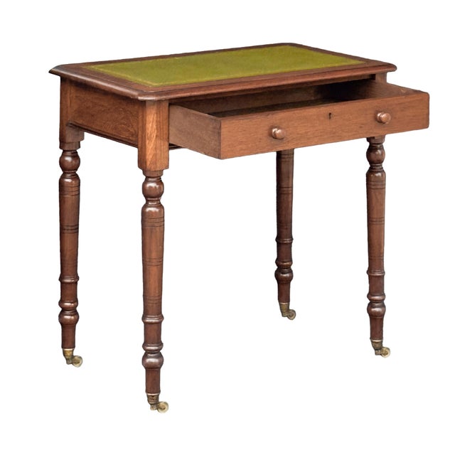 A fine diminutive English library table or writing desk of walnut from the 19th century, featuring a moulded rectangular...