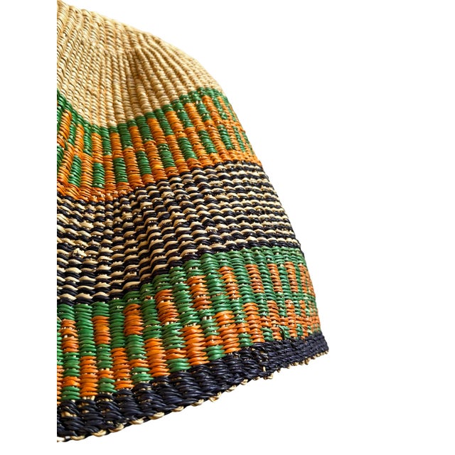 This pendant light began as a traditional Bolga basket from northern Ghana. These baskets were objects of daily use, woven...