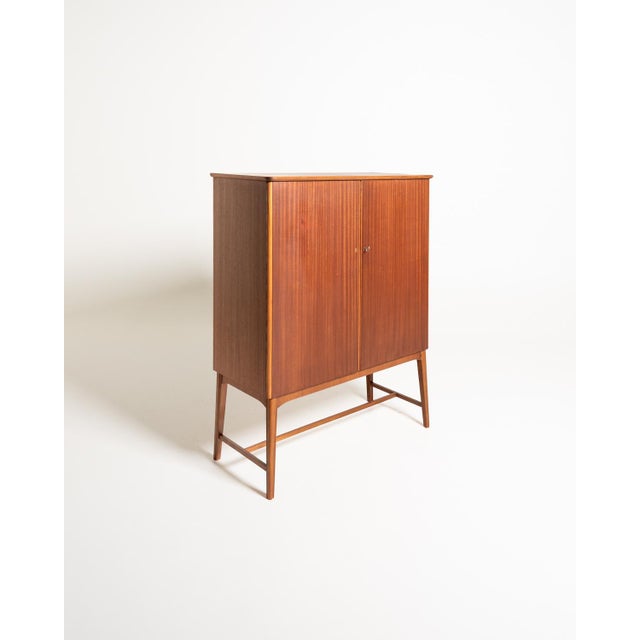 Mahogany cabinet with two hinged doors, shelves, and removable beech trays inside. Svenska Möbelfabrikerna, Sweden,...