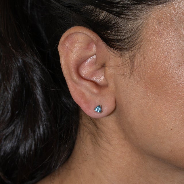 A matched pair of aquamarines in a soft sky-blue sparkles in these solid 14K yellow gold trillion stud earrings....
