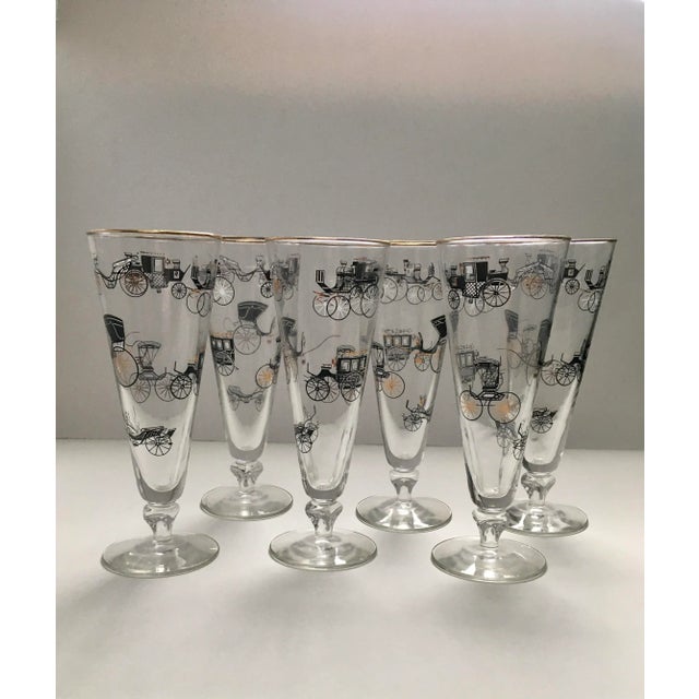 These fun mid 20th century transportation themed glasses feature a charming variety of carriages in black and gold.