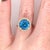 A Swiss topaz sits in a bright sky-blue at the centre of this solid 14K yellow gold ring, surrounded by twenty-five earth-...