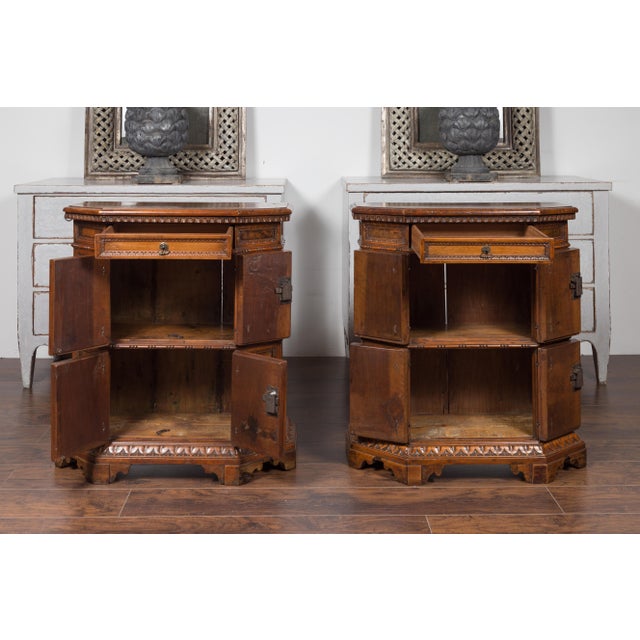 A pair of Italian walnut cabinets from the early 19th century, with canted sides, drawers, doors and carved motifs. Born...