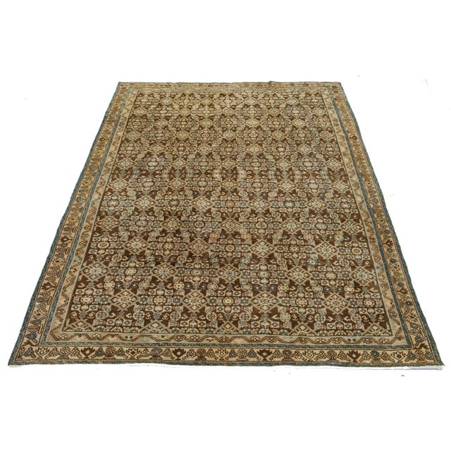 This is a handmade Persian Malayer rug from the 20th century. It has a brown field with blue and beige accents throughout...