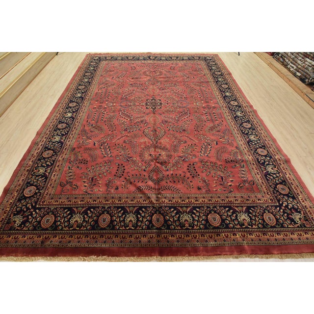 A vintage traditional Sarouk rug hand-knotted with an all-wool pile on a cotton foundation. This finely woven oriental rug...