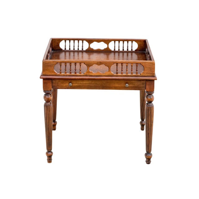 A Theodore Alexander mahogany drinks or chairside table featuring a tooled leather inset top, pierced wood gallery, single...