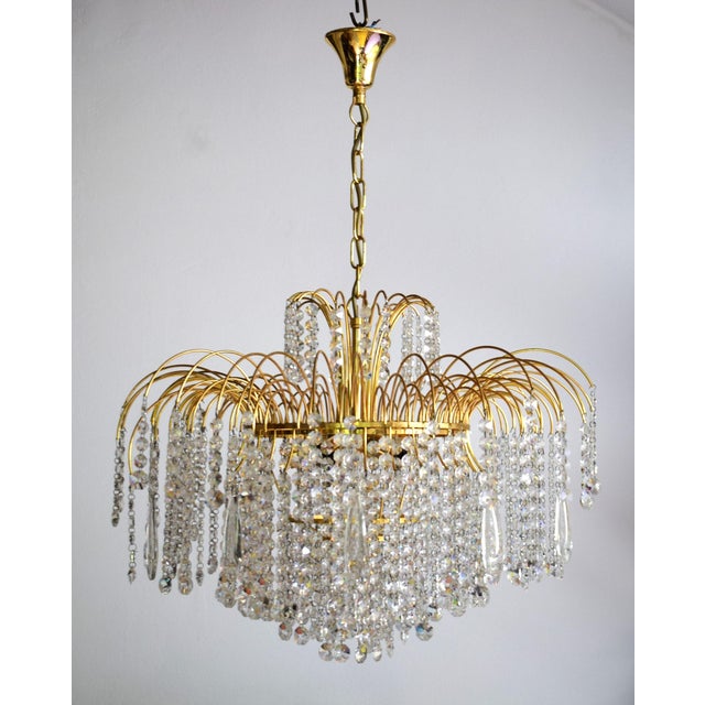 This large waterfall chandelier features a gold-plated mount and is adorned with numerous Swarovski crystals. 6 E14...