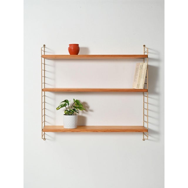 Scandinavian wall shelf system from the 1960s with white lacquered iron uprights and three adjustable oak shelves. Good...