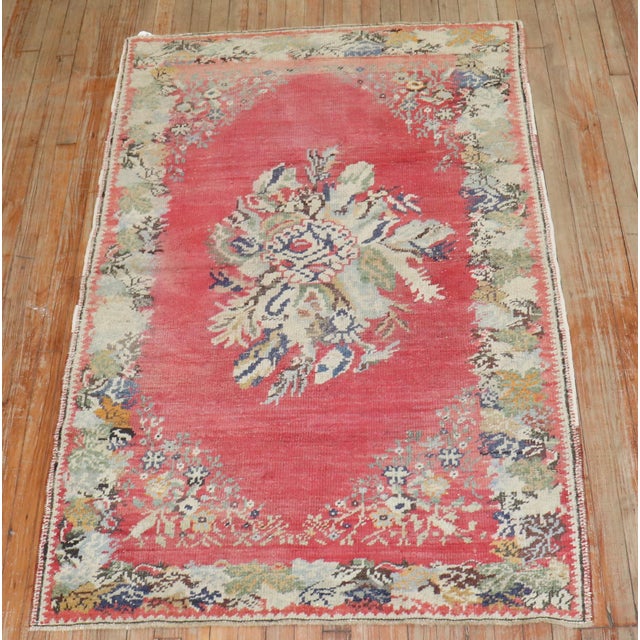 An early 20th-century floral motif Turkish Ghiordes rug in pink. 3'11'' x 5'11''