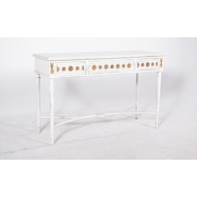Console painted white with gilding. With an elegant design and balanced proportions, it has three front drawers decorated...