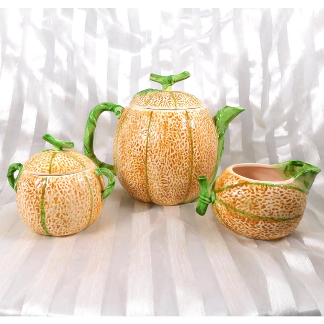 This is a cantelope shaped teapot with lid, sugar bowl with lid and creamer by The Haidon Group. The set is marked as...
