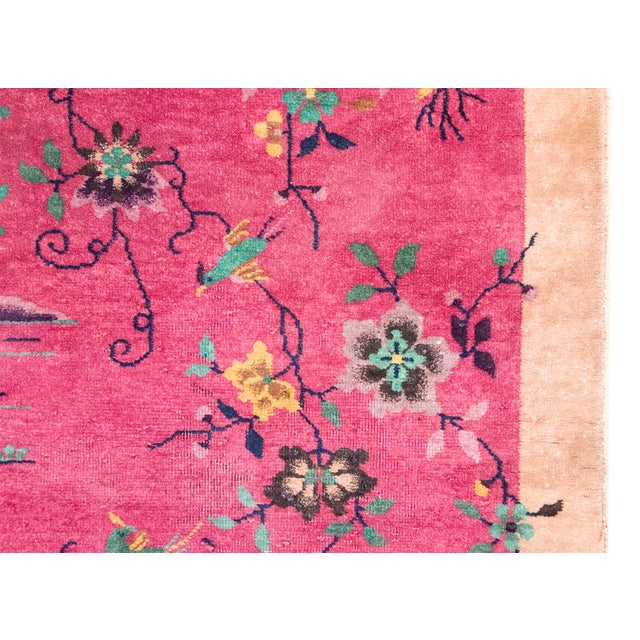 A striking 1930s Chinese Art Deco rug featuring a vibrant magenta field adorned with an asymmetrical composition of...