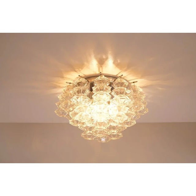 Luxurious pagoda flush mount from Kalmar. In total, 24 clear glasses shaped like a pagoda are held by a chromed frame. The...