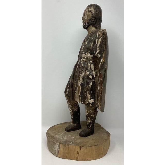 Spanish Colonial figure of a soldier in a long, vertical-grooved cloak or mantle, which is a common feature in antique...