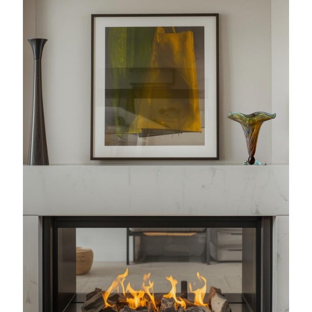 This hand-blown art glass vase is designed in a striking trumpet style, featuring an organic, fluid silhouette that widens...