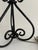 Vintage wrought iron table lamp with an open scrollwork design and black finish. The large looping base and smaller curled...