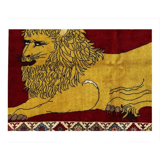 A modern small throw rug handmade during the 21st century with a pictorial design of a male lion in red-over a Gold...