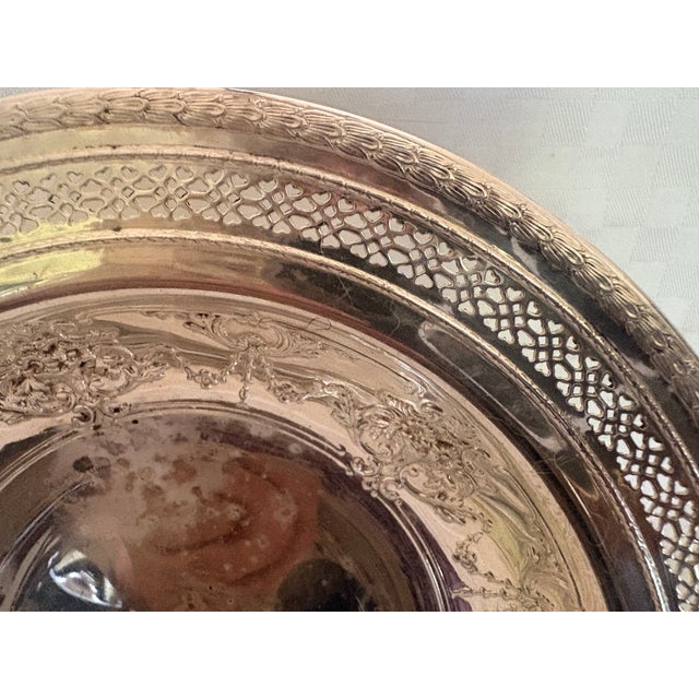 This is a small silver-plate dish with a pierced border and floral and swag interior, Perfect for serving fruit, nuts or...