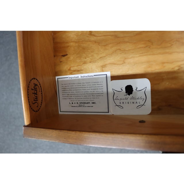 Two-piece cherry china cabinet by Stickley. Upper section features glass doors with divided panes, lighting and adjustable...