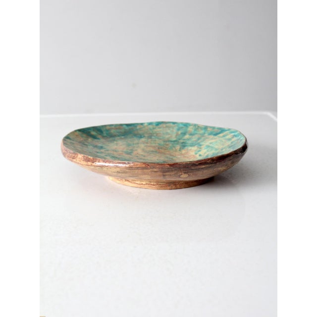 This vintage handmade studio pottery platter features an organic freeform shape with a softly elevated base, highlighting...