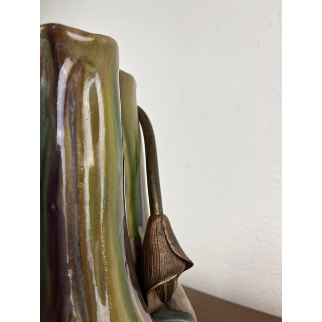 Ceramic vase with iridescent glaze and decorative metal frame, in Art Nouveau style, made in Italy in the 1940s. The vase...