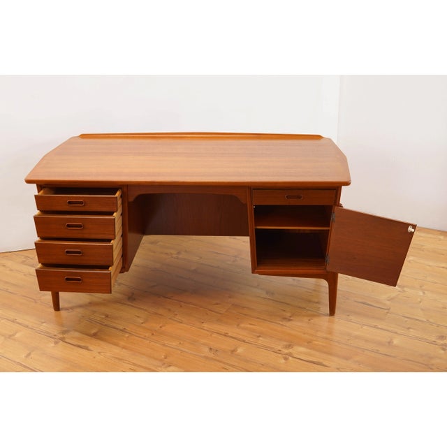 This desk features four drawers on the left side and one drawer and a cabinet on the right side. On the backside is a...