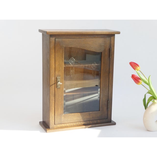 A beautiful antique small oak cabinet with a beveled glass door in the front in a nice shape. The glass has cut floral...