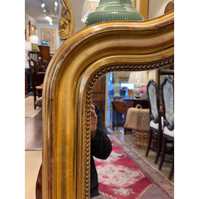 This 19th Century French mirror with camel hump top is top of its class! With its stunning gilt wood hand carved edging...