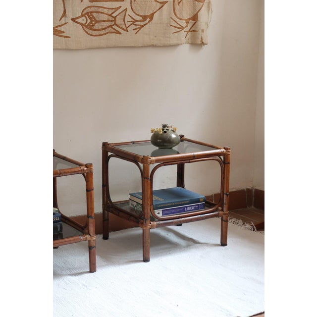 Pair of bedside tables in bamboo and rattan, 1970s. Four straight bamboo uprights, curved hoops on the sides and rattan...
