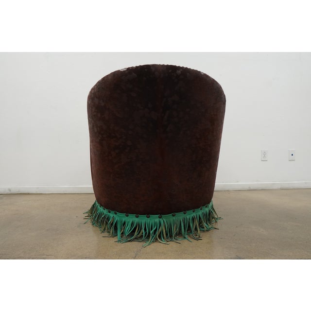 This Western-style swivel barrel chair showcases a bold and distinctive design, blending embossed leather, patterned...