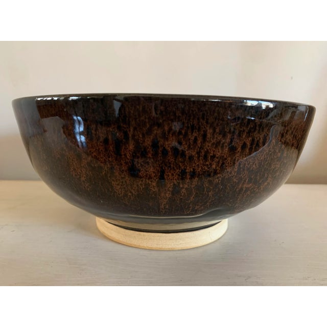 Contemporary, artisan made, glazed, studio pottery decorative bowl. Overall eggplant color with a stunning but subtle deep...
