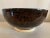 Contemporary, artisan made, glazed, studio pottery decorative bowl. Overall eggplant color with a stunning but subtle deep...