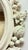25 x 30" Antique white mirror with floral and fruit motif.
