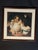 A classic portrait-style framed wall art piece with a warm traditional composition, cream matting, and a dark brown wood...