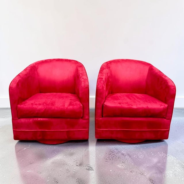 Pair of 1980s vintage swivel club chairs in a red suede fabric. These chairs have a retractable swivel mechanism,...