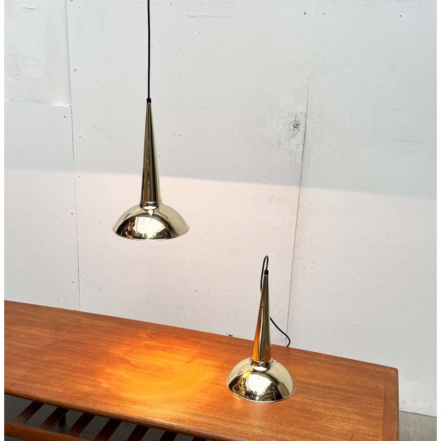 Two impressive brass pendant lights from Denmark. The most striking detail of these lights is the tapered cone that...