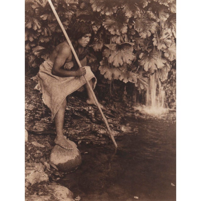 Silver and sepia tone photographic print of an indigenous spearfisher by Edward Sheriff Curtis, image circa 1901...