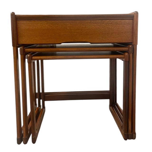 A versatile set of three mid-century modern nesting tables. The largest table features a tiled top with hand-painted...