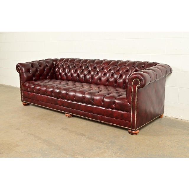 A gorgeous vintage English oxblood tufted leather Chesterfield sofa In the manner of Hancock and Moore, By Classic...