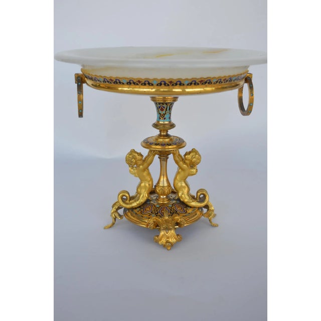 Champleve centerpiece. Tazza held up by two puttis.