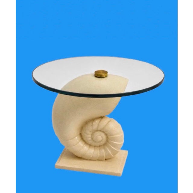 A vintage nautilus seashell carved ivory faux marble stone accent table the perfect coastal design. With a circular...