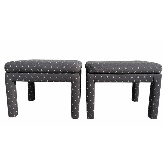 Sculptural Parsons-style ottomans with a clean, tailored profile upholstered in a striking black fabric accented by an...