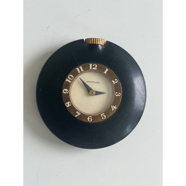 This item is a 1930s Westclox Art Deco purse or handbag watch featuring a black Bakelite case and a brass numeral ring. •...