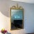 Offering a large vertical mirror with metal laurel leaves throughout. In the manner of Louis XVI Neoclassical Empire. A...
