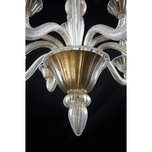 Hand-blown clear glass with gold dust and white glass contours. The chandelier has been completely renovated: new...