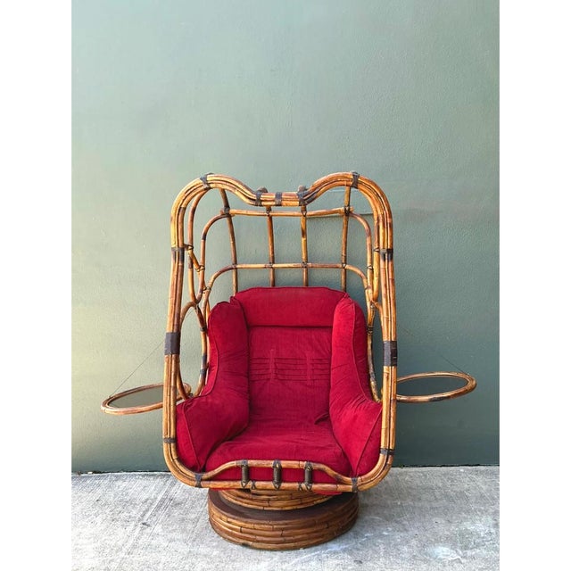 Crafted in the United States during the mid-20th century, this extraordinary bent rattan swivel lounge chair showcases an...